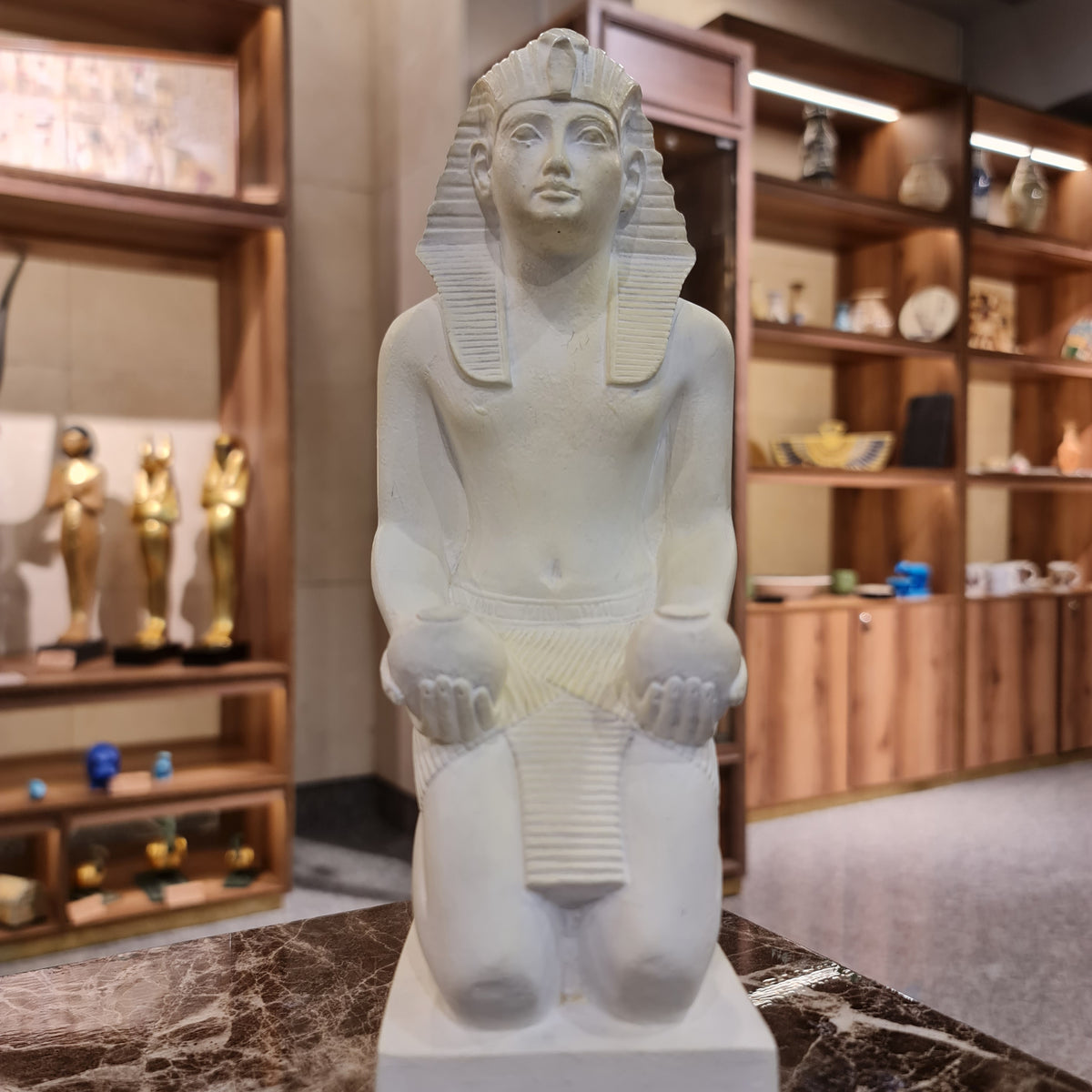 Kneeling Thutmose III statue offering Nu vases, museum reproduction, front view