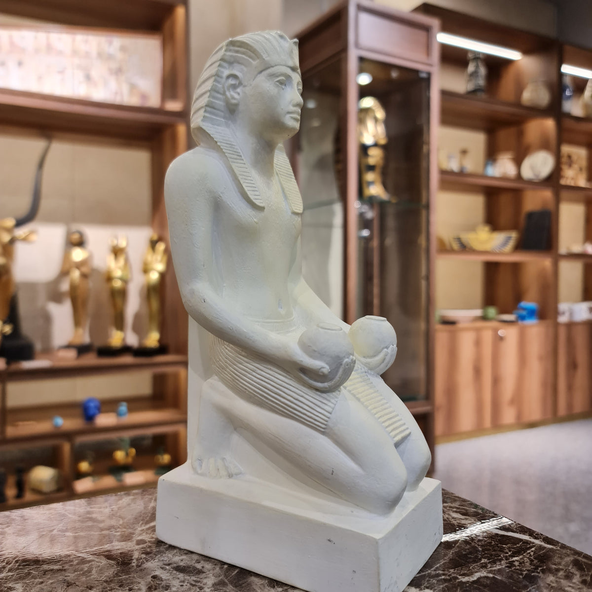 Kneeling Thutmose III statue museum reproduction, side profile