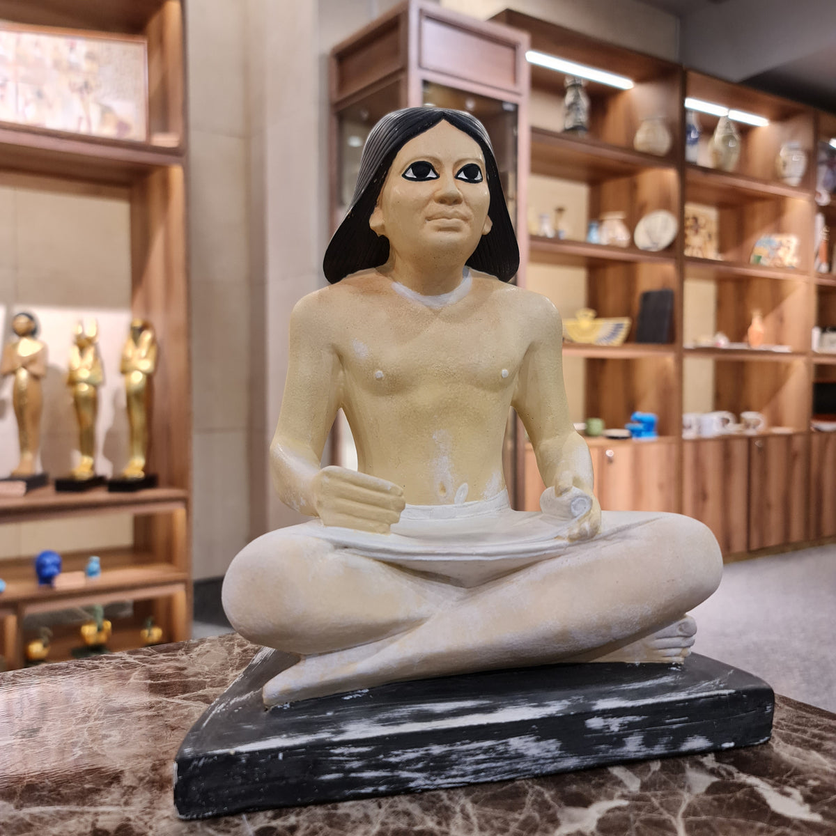 Seated scribe statue museum reproduction, three-quarter angled view