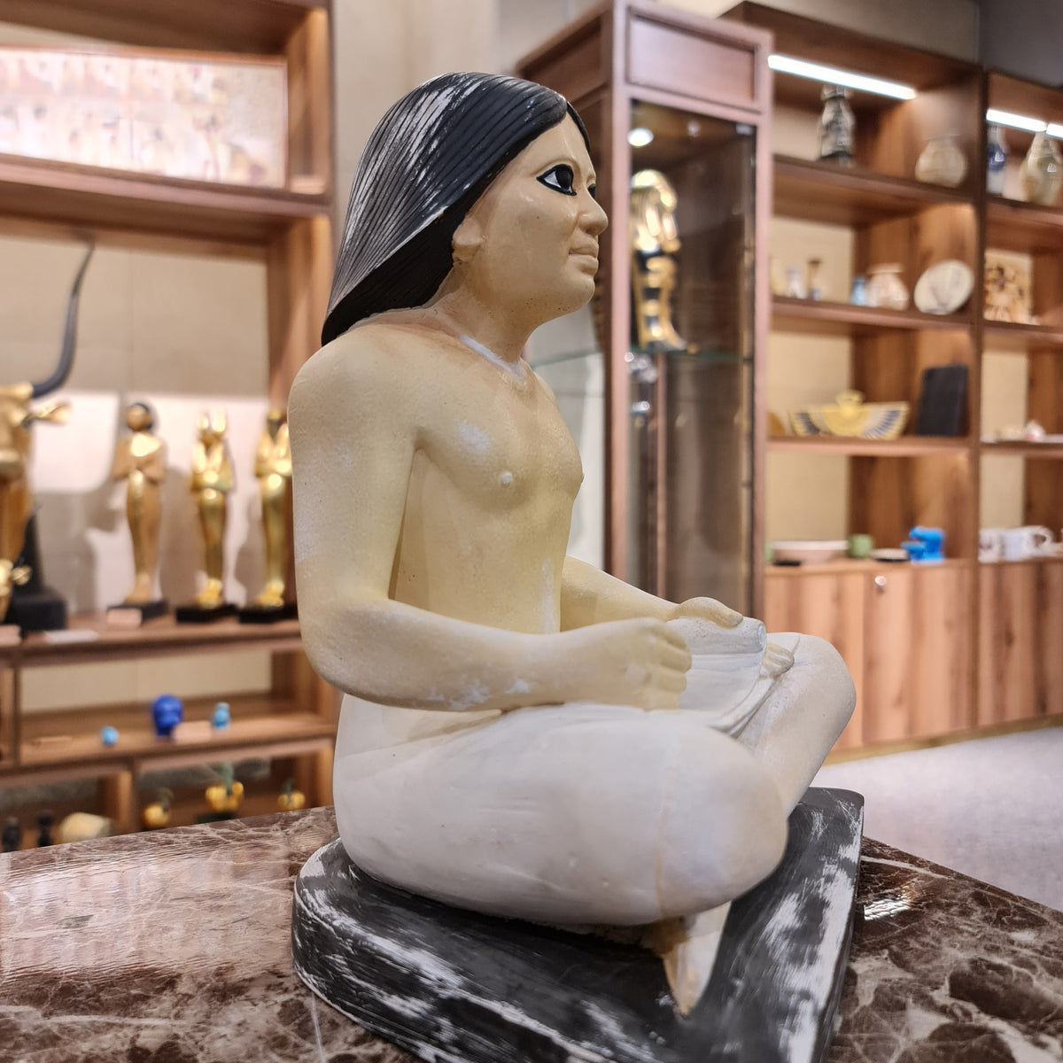 Seated scribe statue museum reproduction, side profile