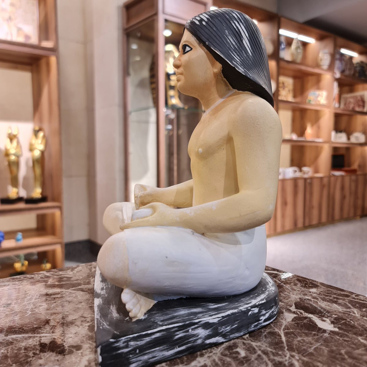 Seated scribe statue museum reproduction, close-up of the papyrus scroll and posture