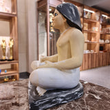 Seated scribe statue museum reproduction, close-up of the papyrus scroll and posture
