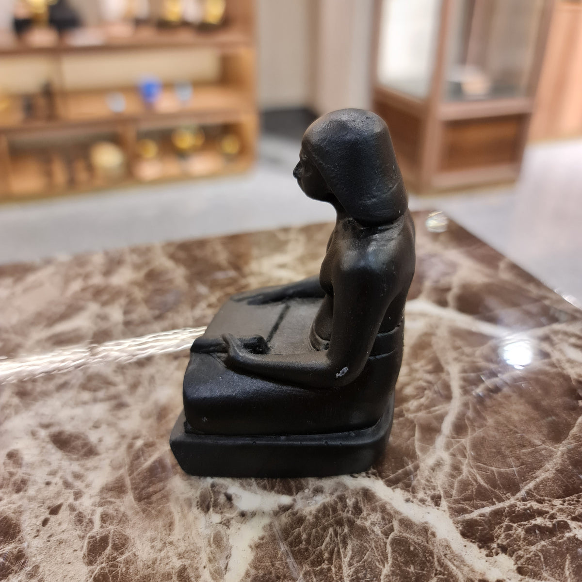 Black seated scribe statue museum reproduction, close-up detail