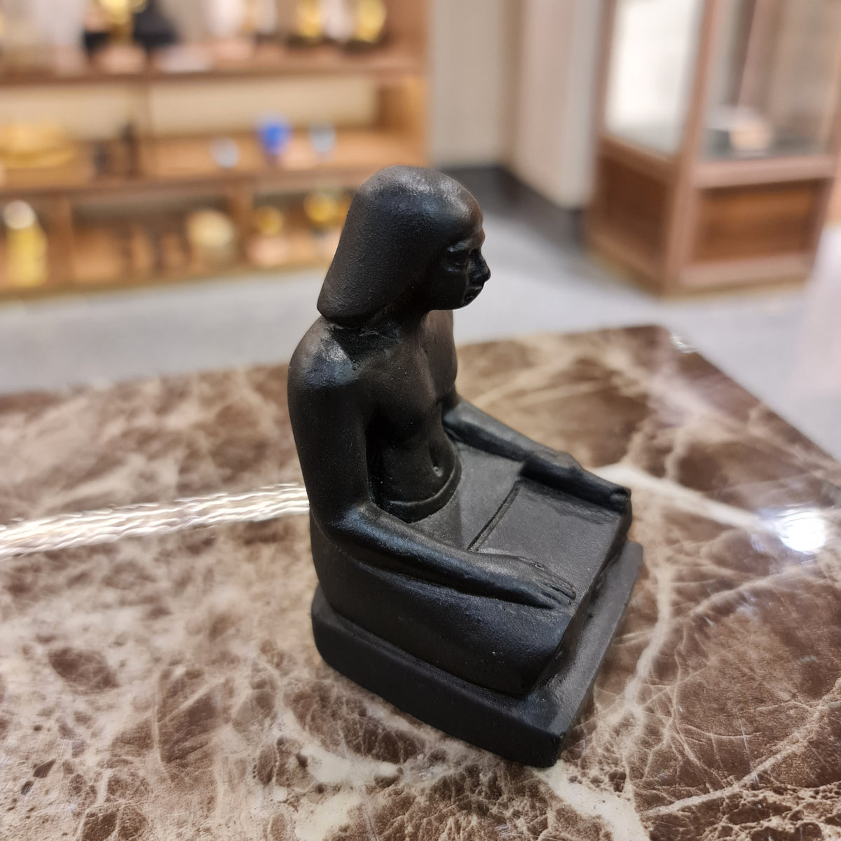 Black seated scribe statue museum reproduction, side profile