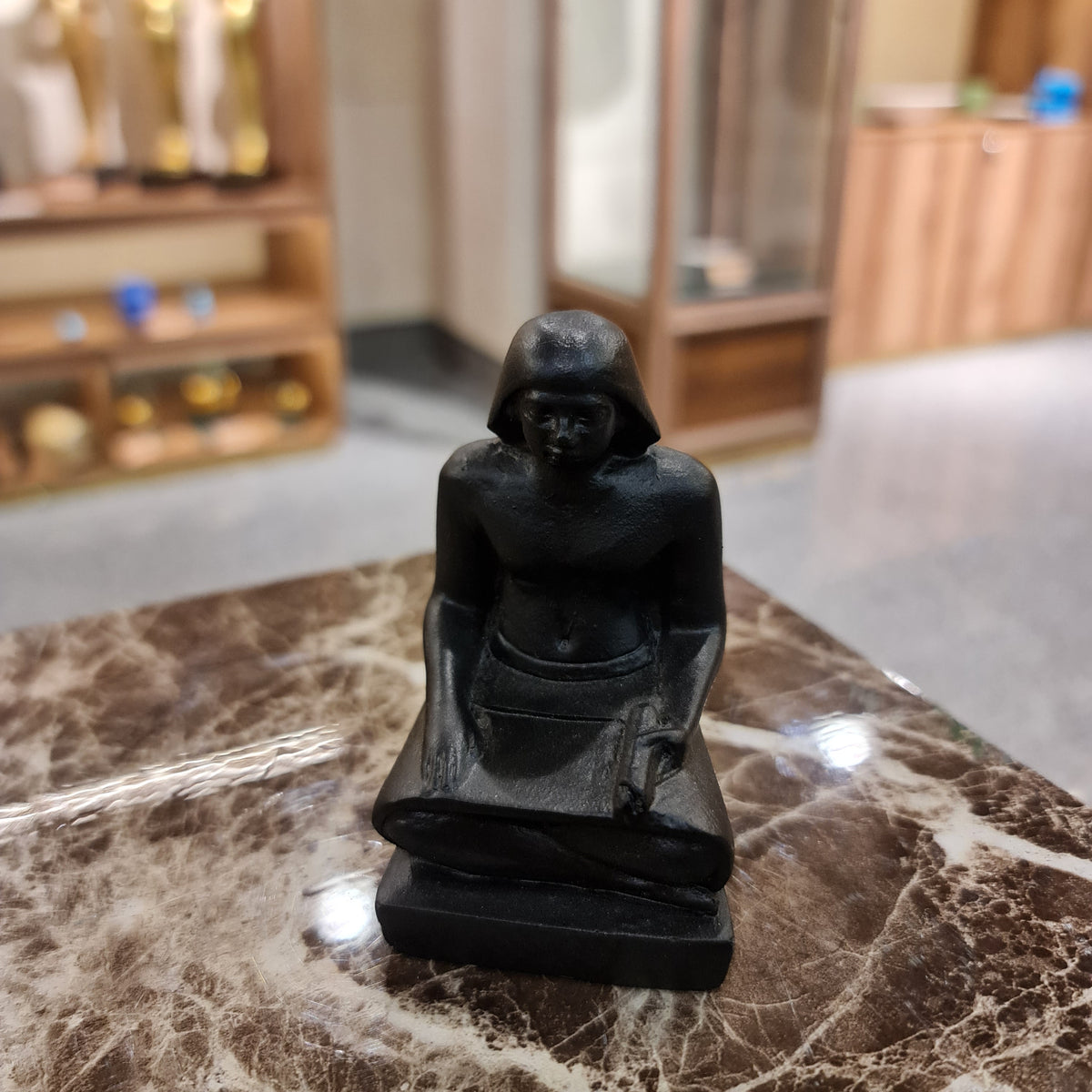 Small black seated scribe statue museum reproduction shown for scale
