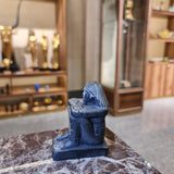 Small black cube block statue shown for scale, museum reproduction