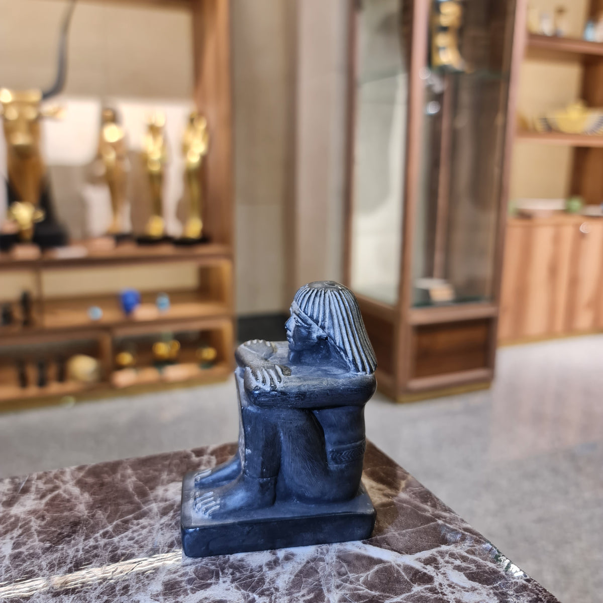 Small black cube block statue shown for scale, museum reproduction