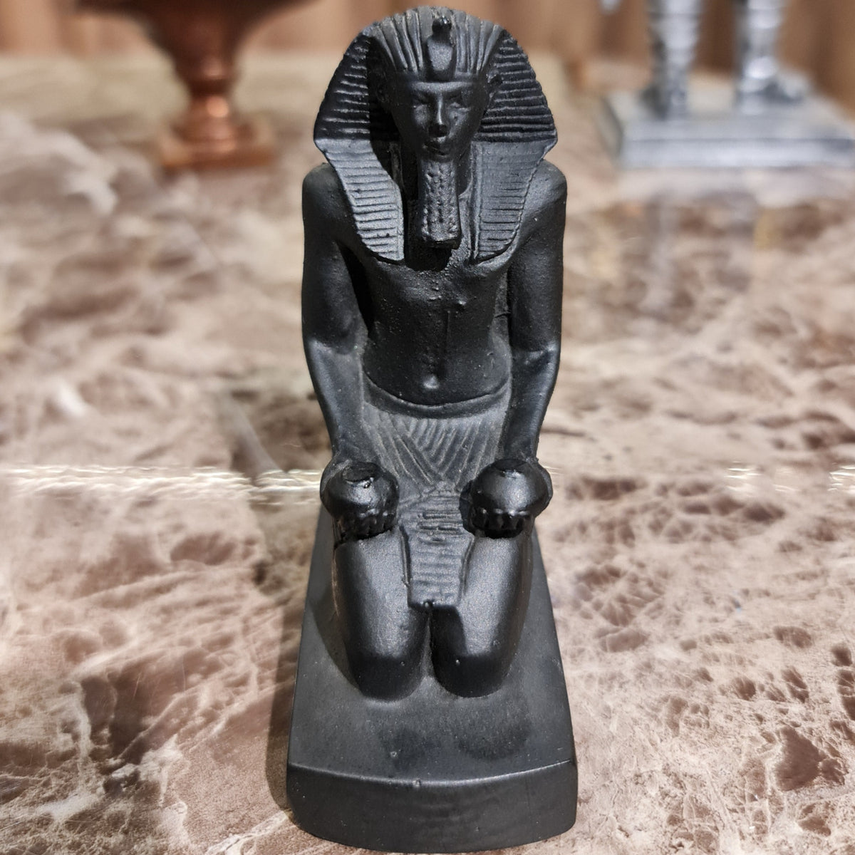 Black kneeling statue of King Thutmose III offering two nu vases, museum reproduction, front view