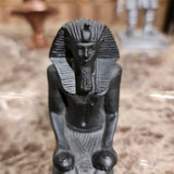 Black kneeling statue of King Thutmose III shown for scale