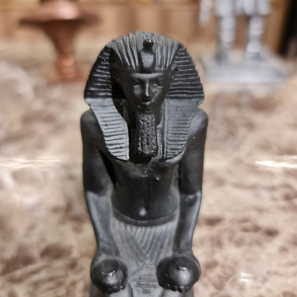 Black kneeling statue of King Thutmose III shown for scale