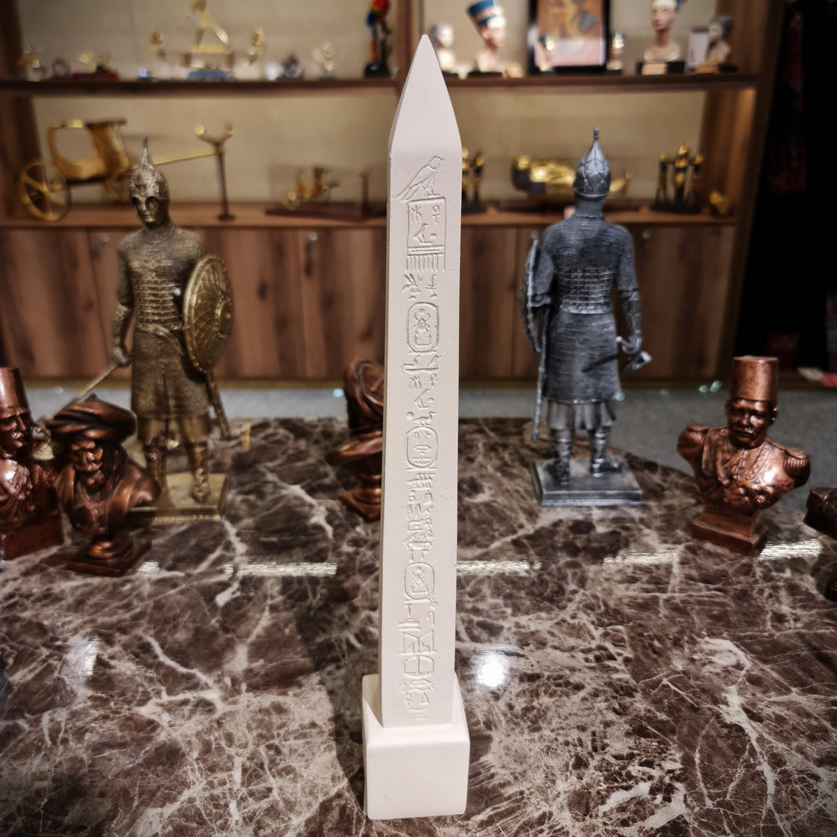 Beige Egyptian obelisk reproduction shown from a side angle