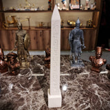Beige Egyptian obelisk reproduction shown from a side angle