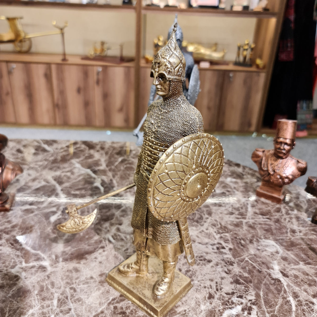 Full display view of the golden armor-clad knight sculpture with battle axe