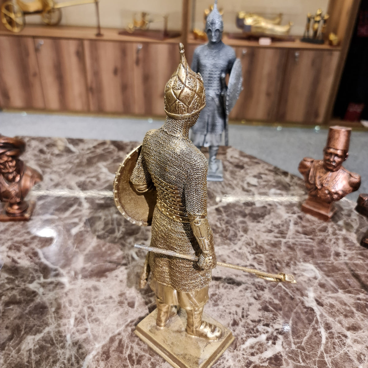 Additional angle of the golden-finish medieval knight sculpture on display