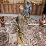 Side profile of the golden medieval knight sculpture showing armor detail