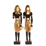 Side view of black and gold guardian statues pair