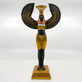 Black and gold Isis statue with a lit candle in the candle holder
