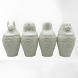 Alabaster canopic jars set, museum reproduction — detail of Duamutef and Qebehsenuef jar lids