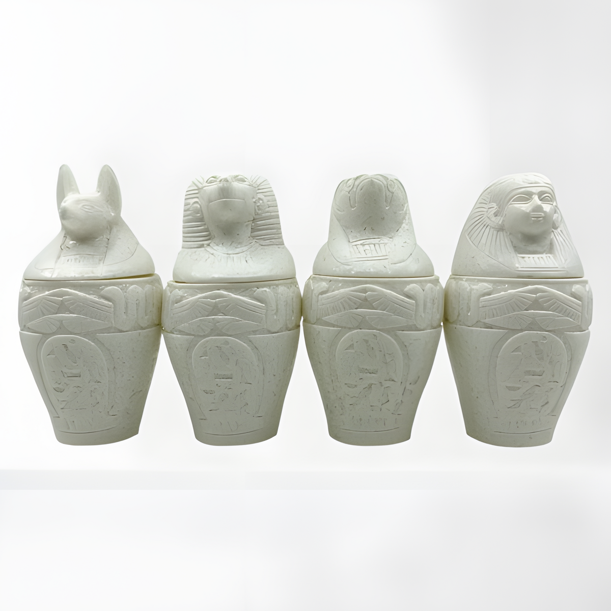 Alabaster canopic jars set, museum reproduction — detail of Duamutef and Qebehsenuef jar lids