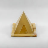 Alabaster pyramid candle holder museum reproduction, lit with a candle inside