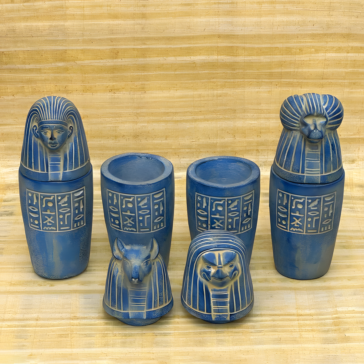 Blue stone canopic jar set, museum reproduction — detail of Duamutef and Qebehsenuef jar lids