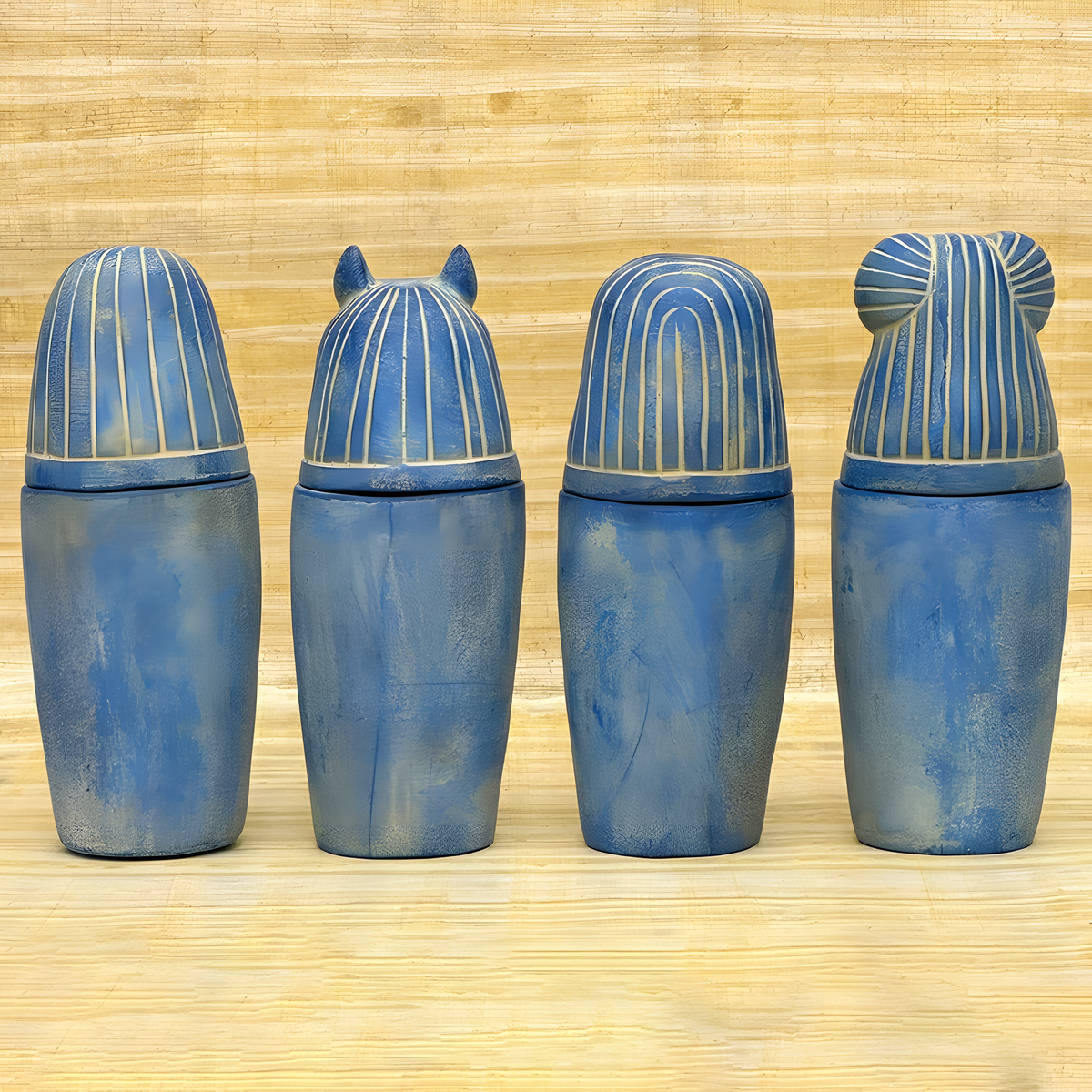 Blue stone canopic jar set, museum reproduction — close-up of carved hieroglyphic detail