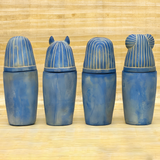 Blue stone canopic jar set, museum reproduction — close-up of carved hieroglyphic detail