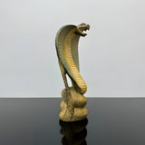 Stone uraeus cobra statue, museum reproduction — side view showing rearing cobra form