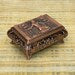 Copper alloy Heh jewelry box shown alongside jewelry pieces for scale