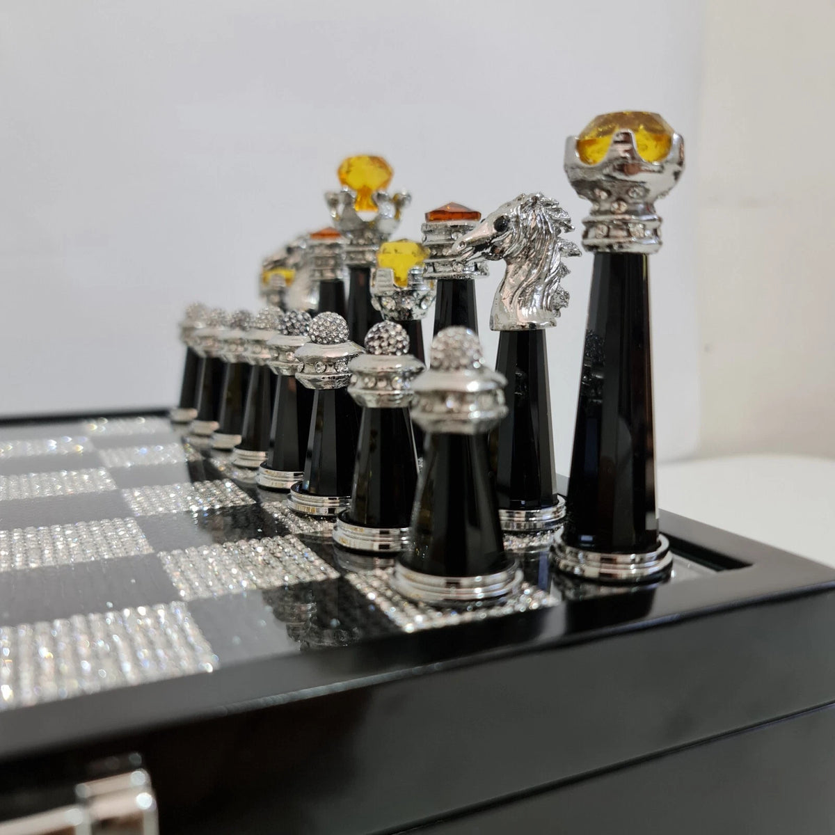 Side view of crystal chess set on velvet wood base
